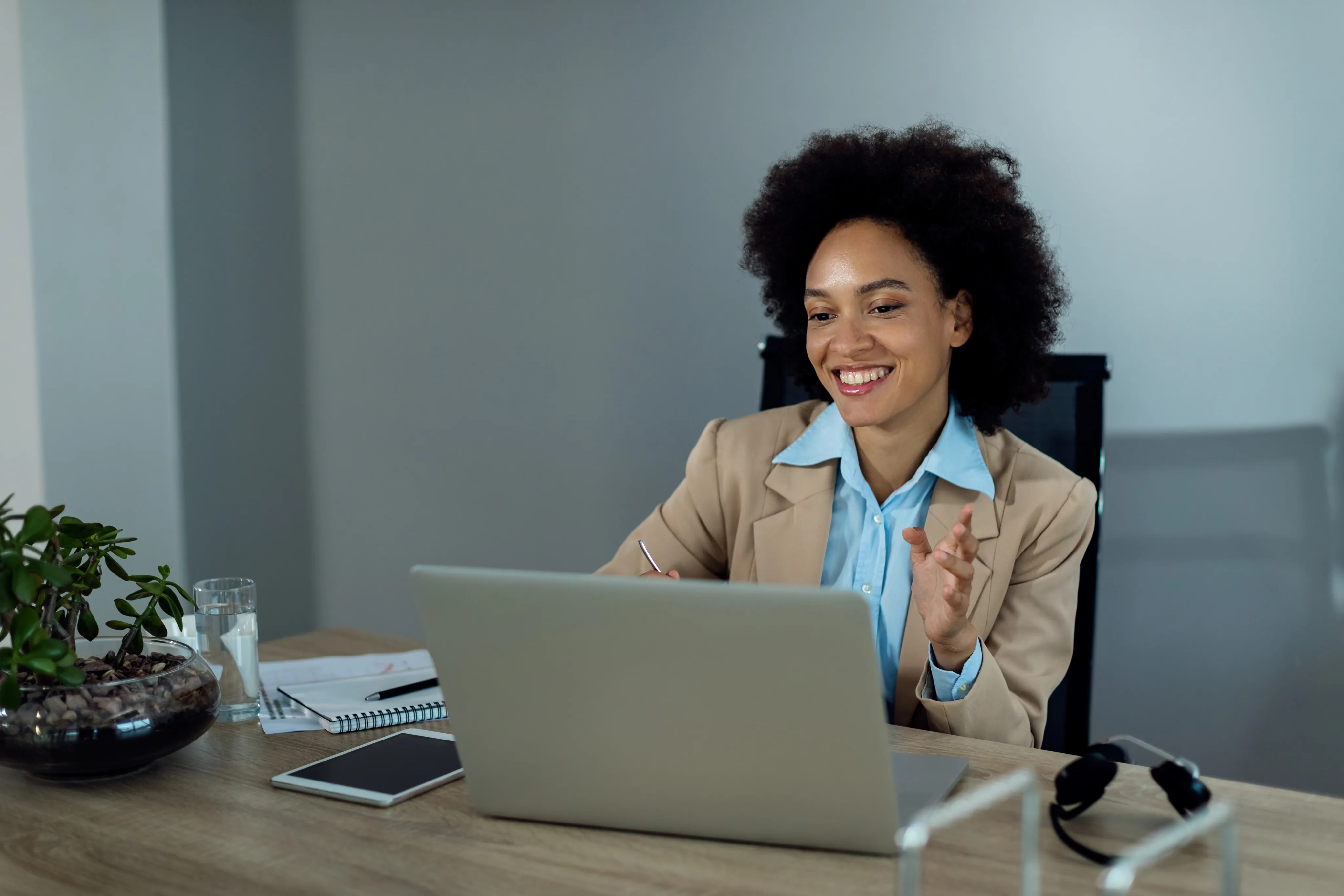 Professional woman smiling while working on laptop